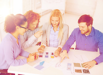 Image showing smiling creative team looking at sketch