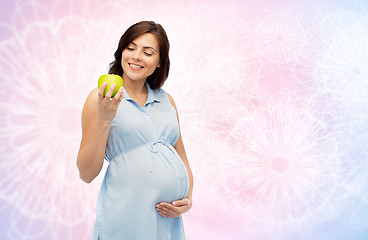 Image showing happy pregnant woman looking at green apple