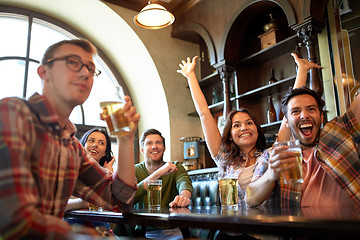 Image showing friends with beer watching football at bar or pub