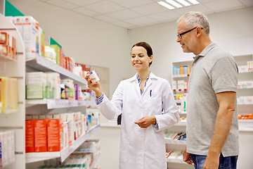 Image showing pharmacist showing drug to senior man at pharmacy