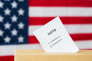 Image showing vote inserted into ballot box slot on election