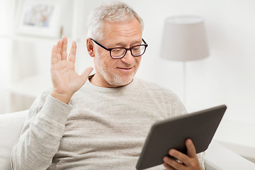 Image showing senior man having video call on tablet pc at home