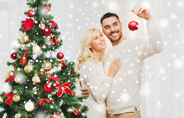 Image showing happy couple decorating christmas tree at home