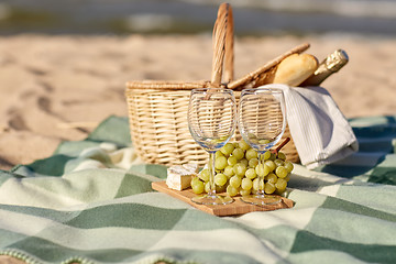 Image showing picnic basket with wine glasses and food on beach