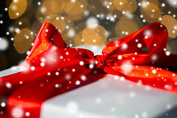 Image showing close up of christmas gift with bow over lights