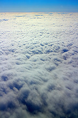 Image showing Clouds pass under wing of plane