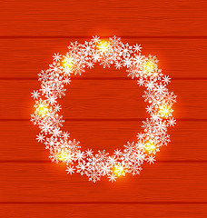 Image showing Christmas circle frame made in snowflakes on red wooden backgrou