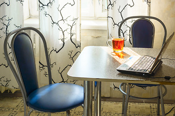 Image showing Laptop and cup of tea on table