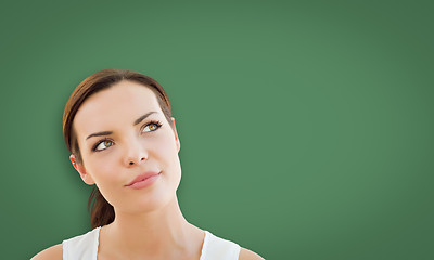 Image showing Attractive Young Woman Looking Up to Blank Chalk Board