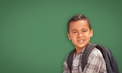 Image showing Cute Hispanic Boy In Front of Blank Chalk Board