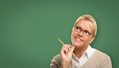 Image showing Attractive Young Woman with Pencil In Front of Blank Chalk Board