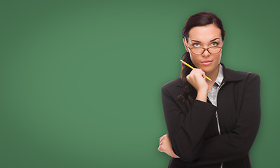 Image showing Serious Young Woman with Pencil In Front of Blank Chalk Board