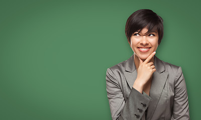 Image showing Attractive Young Woman Looking Up to Blank Chalk Board