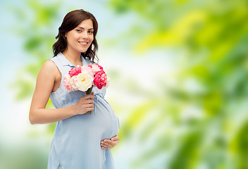 Image showing happy pregnant woman with flowers touching belly