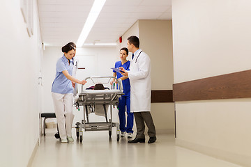 Image showing medics with woman on hospital gurney at emergency