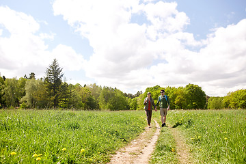 Image showing happy couple with backpacks hiking outdoors