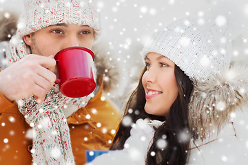 Image showing happy couple with tea cups over winter landscape