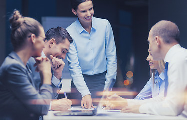 Image showing smiling female boss talking to business team