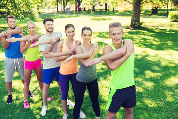 Image showing group of friends or sportsmen exercising outdoors