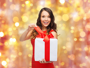 Image showing smiling woman in red dress with christmas gift