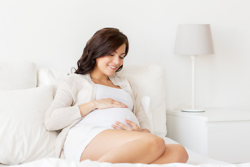 Image showing happy pregnant woman lying on bed at home