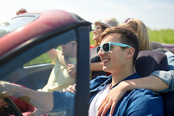 Image showing happy friends driving in cabriolet car at country