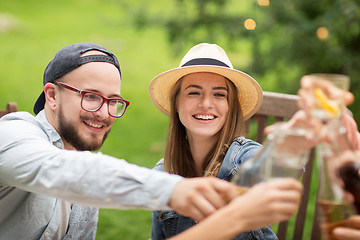 Image showing happy friends clinking glasses at summer garden