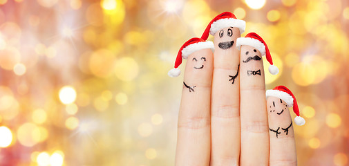 Image showing close up of hand with four fingers in santa hats