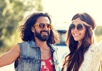 Image showing smiling young hippie couple over minivan car