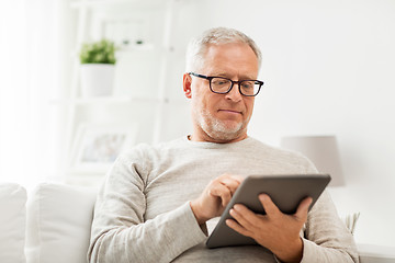 Image showing senior man with tablet pc at home