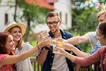 Image showing happy friends clinking glasses at summer garden