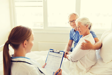 Image showing senior woman and doctor with clipboard at hospital