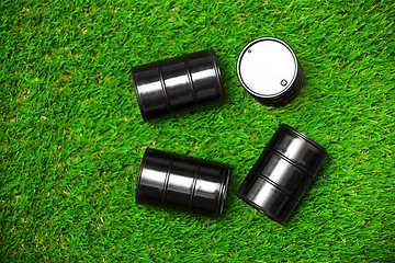 Image showing High angle view on four oil barrels on a grass