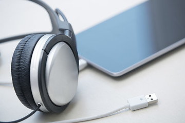 Image showing Headphones and tablet computer on a table