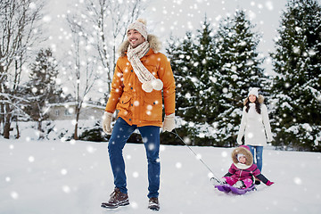 Image showing happy family with sled walking in winter outdoors