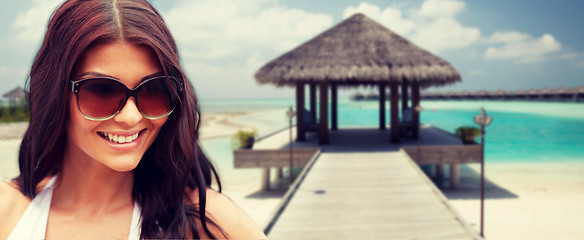 Image showing smiling young woman with sunglasses on beach