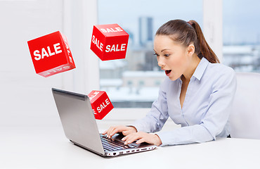 Image showing surprised businesswoman with laptop and sale signs
