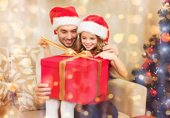 Image showing smiling father and daughter opening gift box