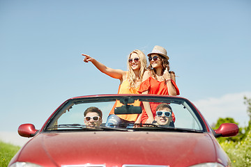 Image showing happy friends driving in cabriolet car at country