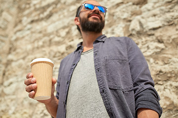 Image showing close up of man with paper coffee cup on street