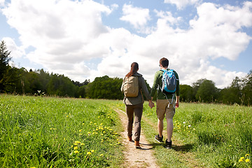 Image showing happy couple with backpacks hiking outdoors