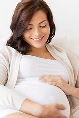 Image showing happy pregnant woman lying on bed at home