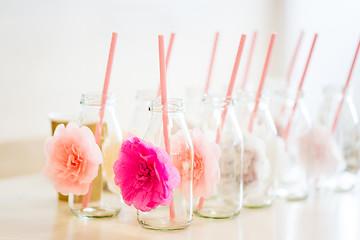 Image showing close up of glass bottles for drinks with straws