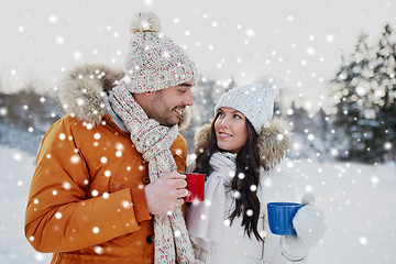 Image showing happy couple with tea cups over winter landscape