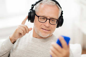 Image showing happy senior man with smartphone and headphones