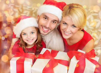 Image showing smiling family holding many gift boxes