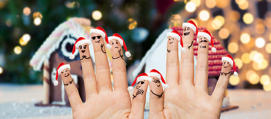 Image showing close up of fingers with smiley in santa hats