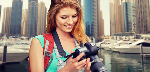 Image showing woman with backpack and camera over dubai city