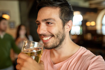 Image showing close up of happy man drinking beer at bar or pub