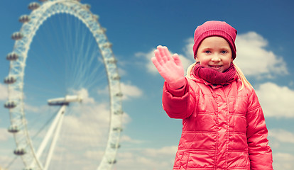 Image showing happy little girl waving hand over ferry wheel